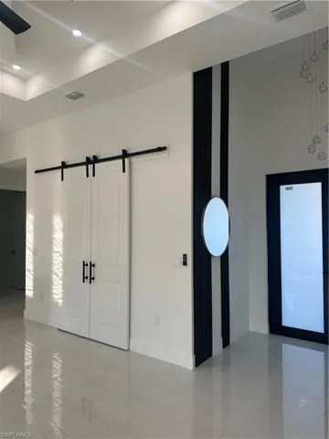 Unfurnished room featuring a barn door