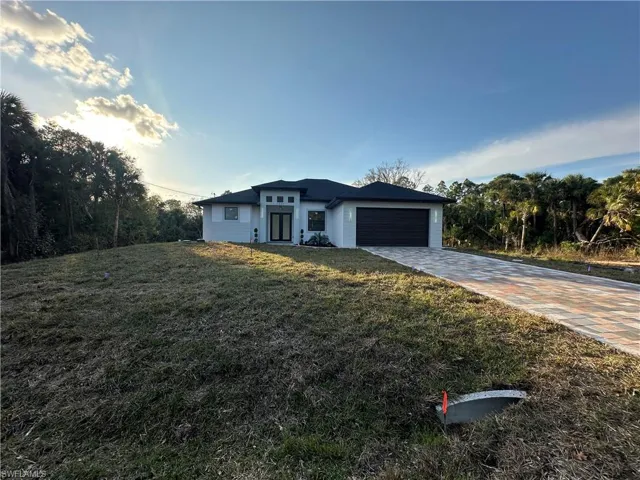 View of front of home featuring a front lawn and a garage