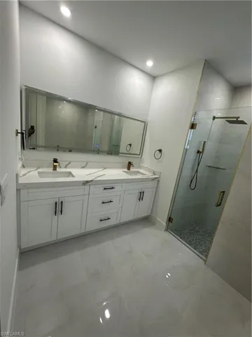 Bathroom featuring vanity and a shower with door
