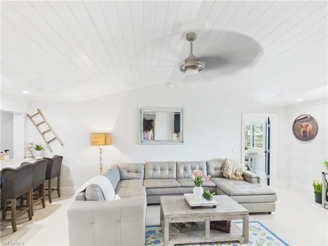 Vaulted shiplap ceiling featuring a contemporary ceiling fan
