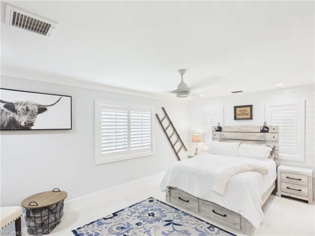 Bedroom with white wood-finish flooring, plantation shutters, recessed lighting, and a ceiling fan