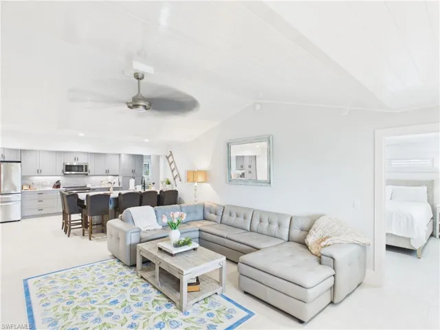 Open-concept living space featuring vaulted ceilings with wood-paneling, recessed lighting, and wood-finish flooring