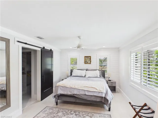Bedroom featuring light wood-finish flooring and white shiplap accent wall