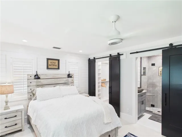 Bedroom featuring shiplap accent walls and a ceiling fan with integrated lighting