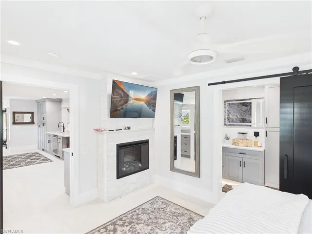 Modern interior featuring a white-stacked stone fireplace with a television above