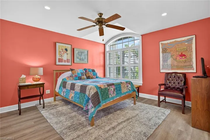 Bedroom with light wood-type flooring, a ceiling fan, lofted ceiling, and recessed lighting