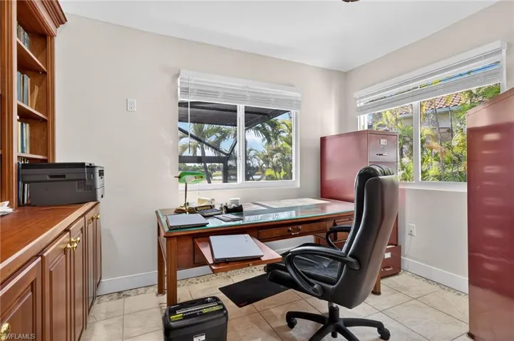 Office with light tile patterned flooring and plenty of natural light