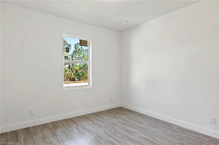 Spare room with a wealth of natural light and light wood-type flooring