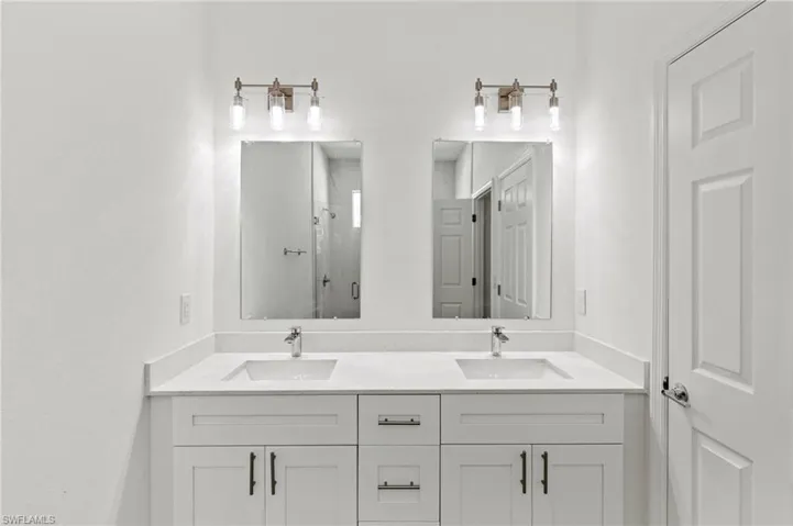 Bathroom featuring walk in shower and double sink vanity