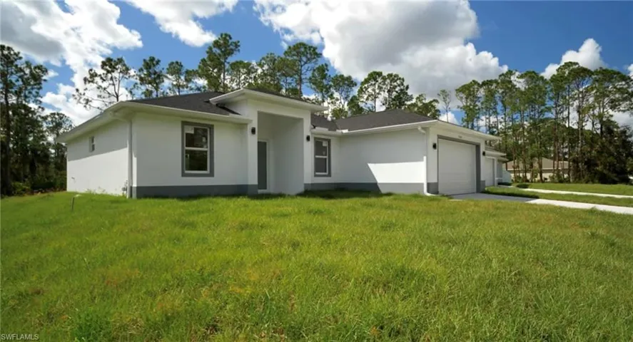 Ranch-style house with a garage and a front lawn