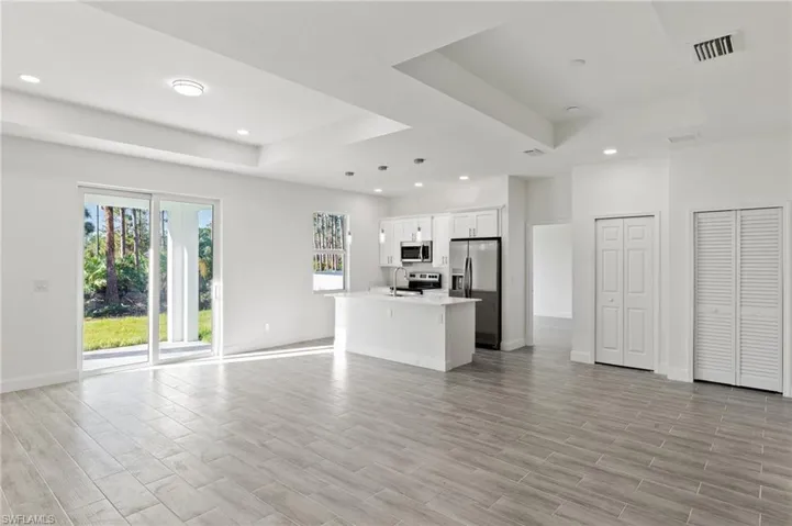 Unfurnished living room featuring sink and a tray ceiling