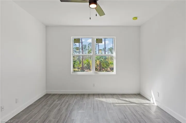 Unfurnished room with hardwood / wood-style flooring and ceiling fan