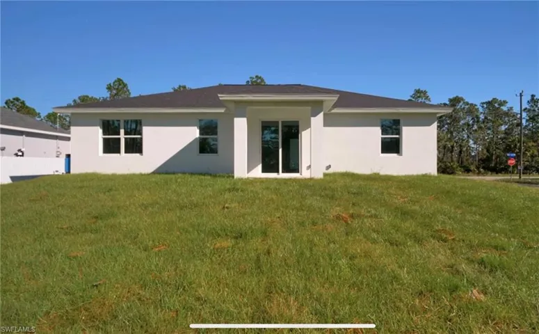 Back of property featuring a lawn