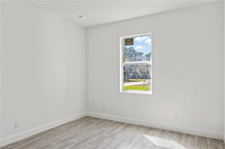 Empty room with light hardwood / wood-style floors and a wealth of natural light