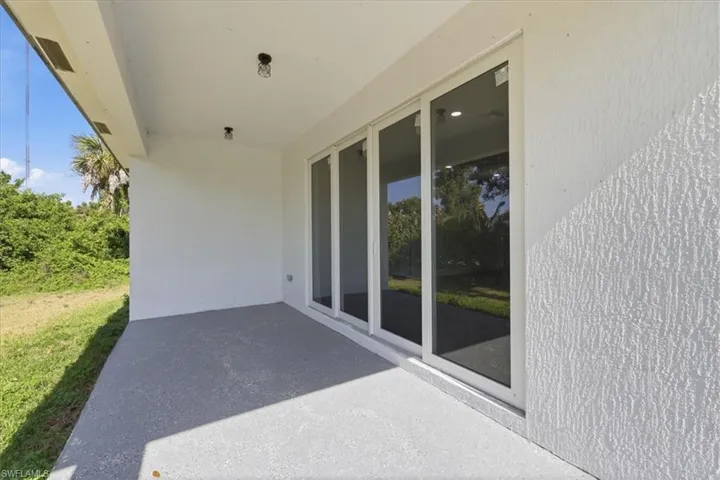 Covered patio featuring a textured concrete floor, recessed lighting, and a multi-panel sliding glass door system