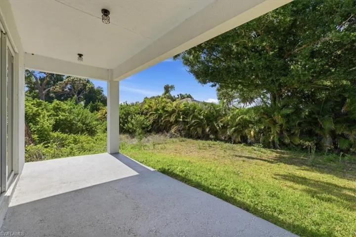 Covered concrete patio with overhead lighting fixtures