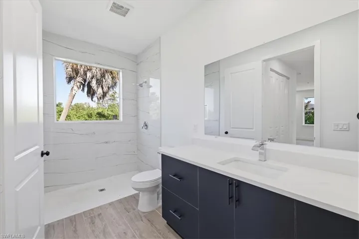 Contemporary bathroom featuring a dark wood-finish vanity with a white countertop and undermount sink