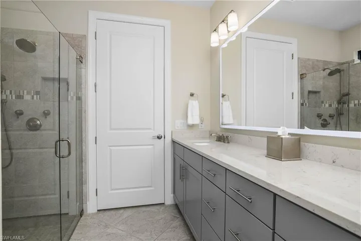 Owner bath features frameless glass shower, dual sinks, plenty of cabinet storage space, and a large walk-in closet with custom built in shelving.