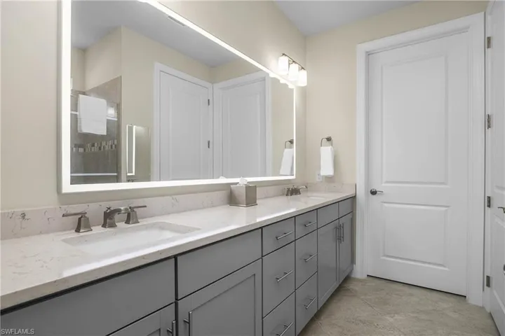 Custom back-lit mirror is a focal point in the owner bath.