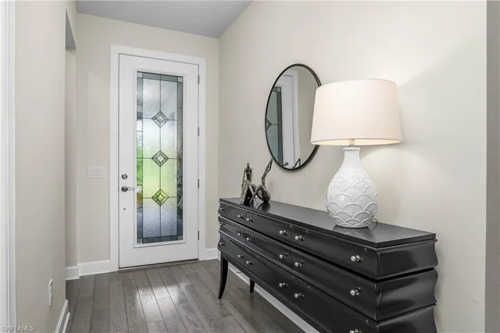Welcoming foyer includes impact front door with decorative glass, and hardwood flooring.