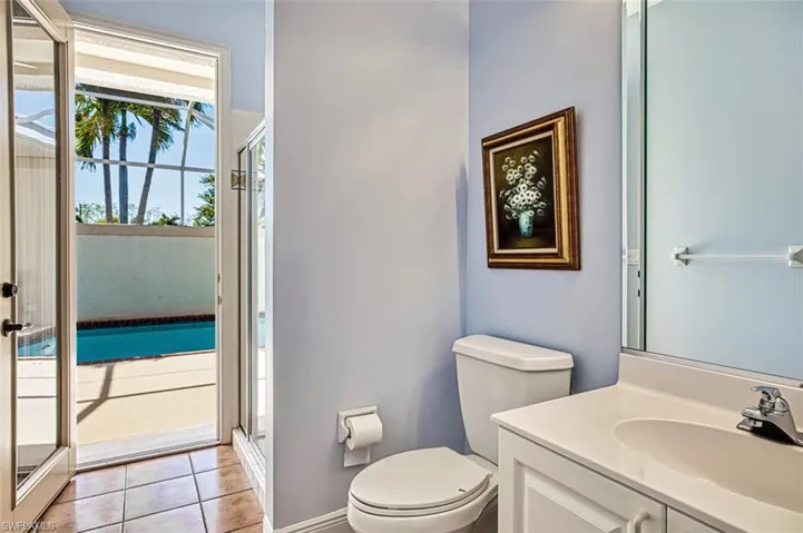 Bathroom with vanity, toilet, a shower with shower door, and tile patterned flooring