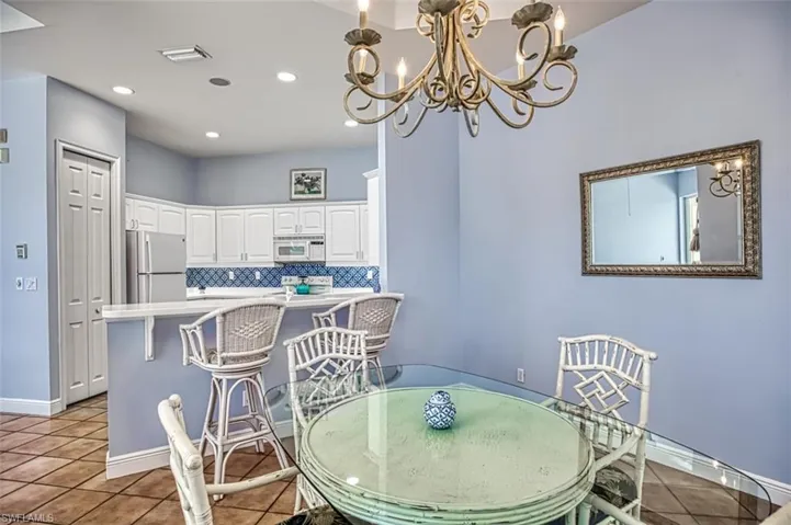 Tiled dining space featuring an inviting chandelier