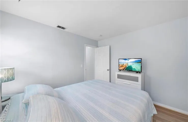 Bedroom featuring wood finished floors and baseboards