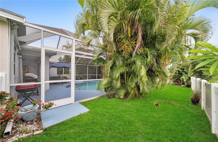 View of yard featuring glass enclosure, a sunroom, and an outdoor pool