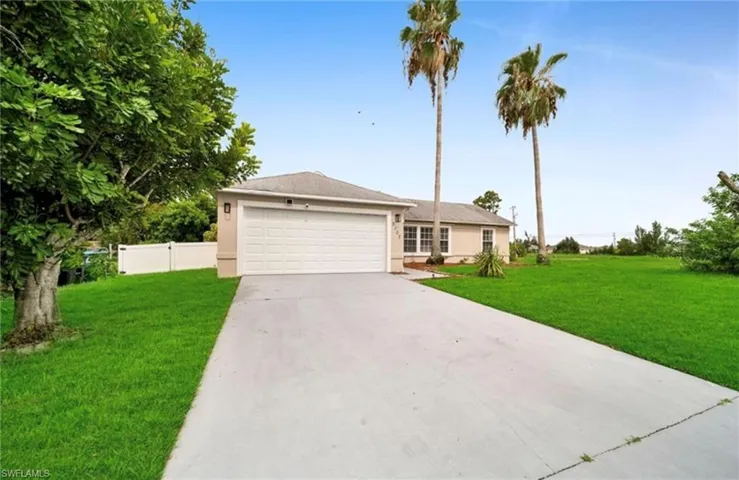 Ranch-style home with driveway, a garage, and stucco siding
