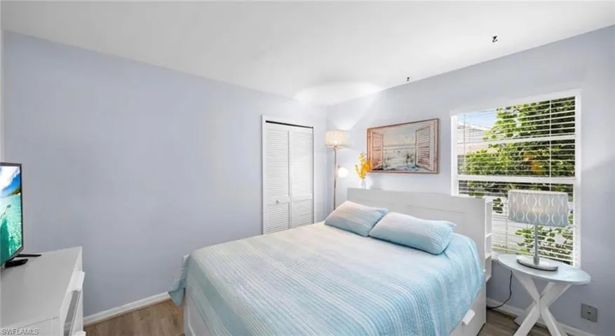 Bedroom with wood finished floors and a closet