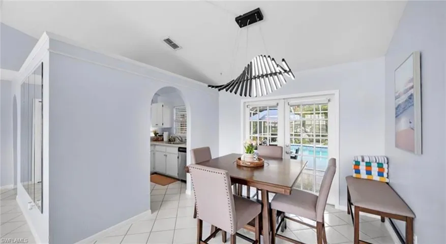 Dining area featuring arched walkways and light tile patterned flooring