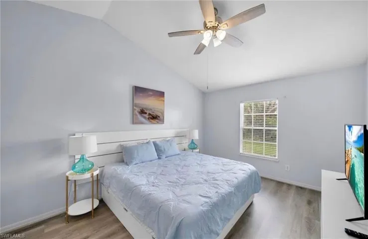 Bedroom featuring vaulted ceiling, light wood-type flooring, and ceiling fan