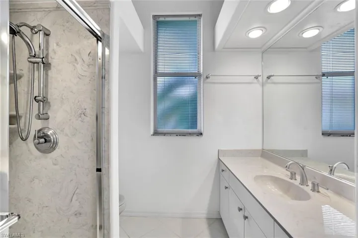 Bathroom featuring tile floors, vanity, walk in shower, and toilet,  This bathroom services the 2nd bedroom and can also be the pool bathroom.