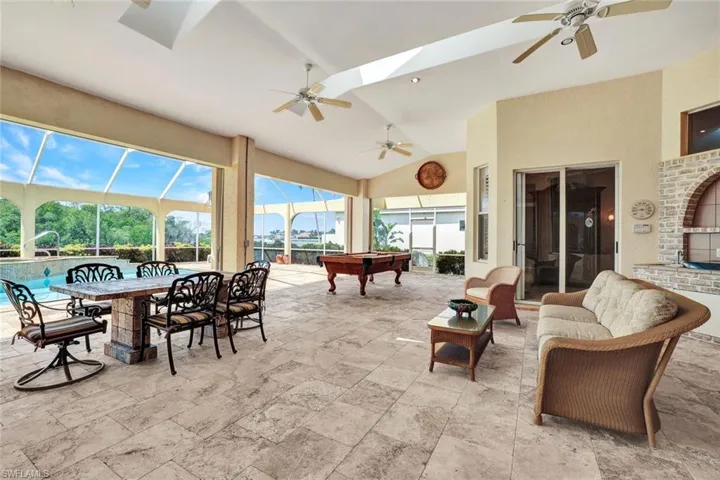 View of immense covered lanai with fans and skylights. There is plenty of space to enjoy the fabulous views from various seating areas & pool table.