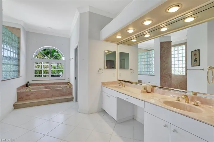 Primary Bathroom with tile flooring, a bathing tub, double vanities, a separate walk in shower, a separate water closet, a walk in closet and a linen closet.