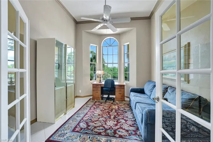Home Office with glass french doors, crown molding, and light tile floors looking out to the front of the property as boats pass by to and from  Windstar's marina.