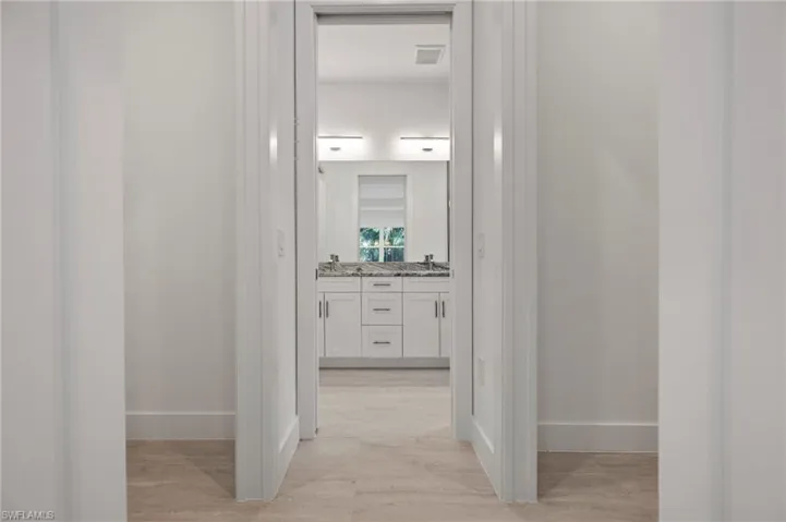 Hallway featuring light wood-type flooring and baseboards