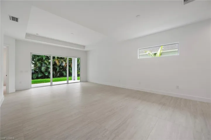 Unfurnished room with a raised ceiling and baseboards