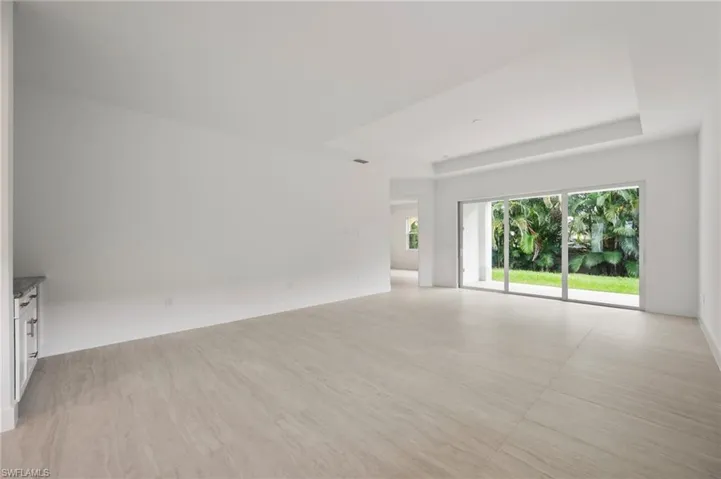 Spare room with a tray ceiling and light wood-style floors