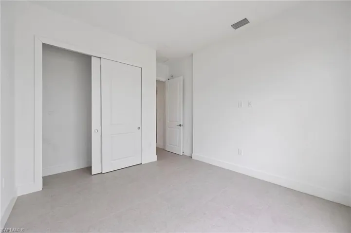 Unfurnished bedroom with a closet and light tile patterned floors
