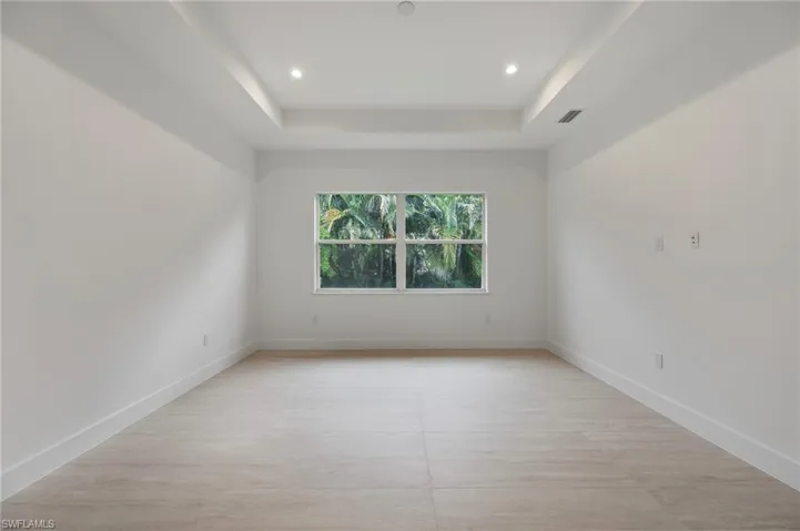 Spare room with recessed lighting and a raised ceiling