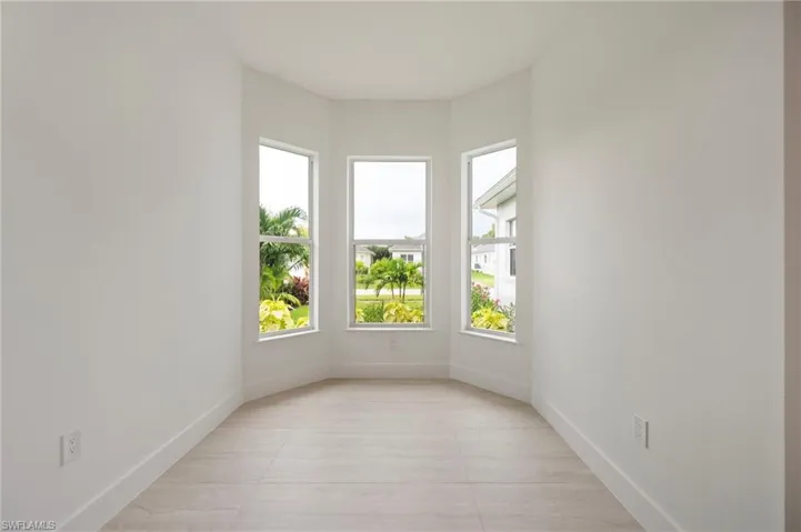 Empty room with baseboards and light tile patterned floors