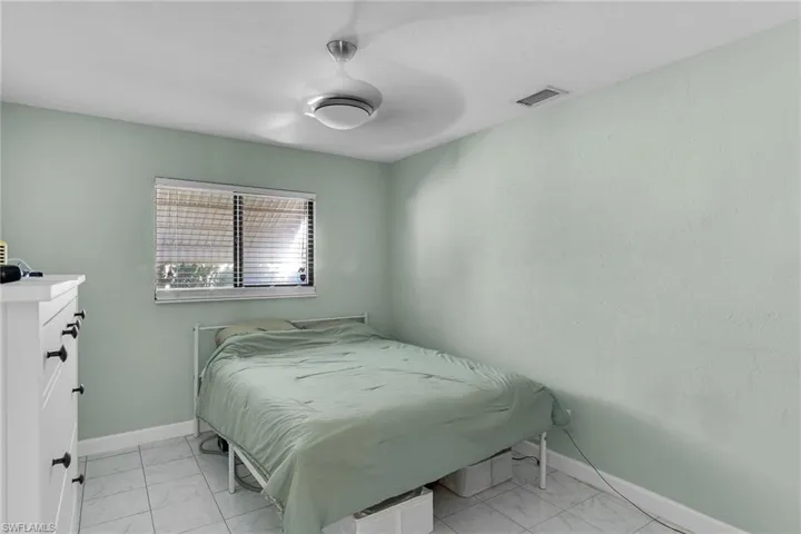 Bedroom with light marble finish flooring