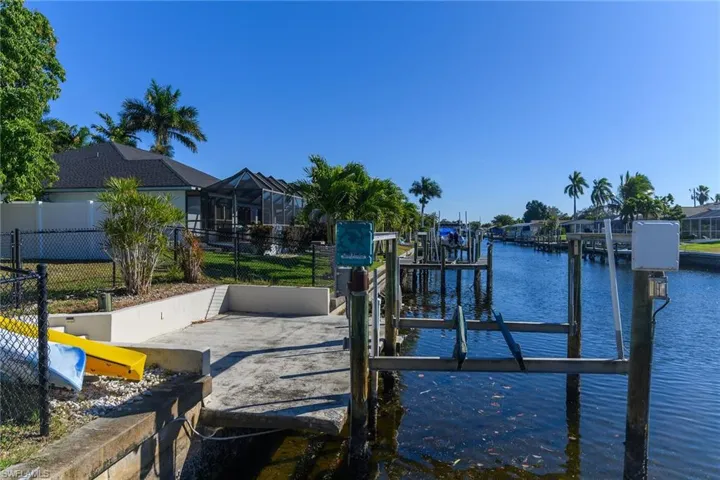 Dock featuring a water view, boat lift, a lanai, and a sunroom