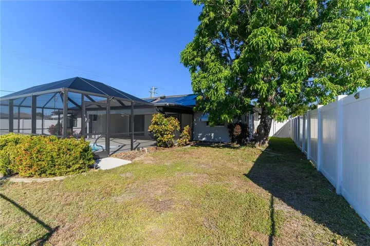 Rear view of house featuring a lanai, a sunroom, and a fenced backyard