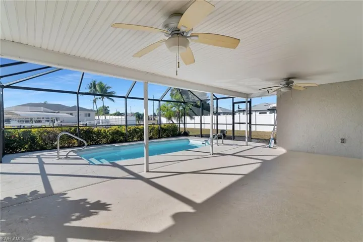 View of swimming pool with glass enclosure, a patio, a sunroom, and a residential view