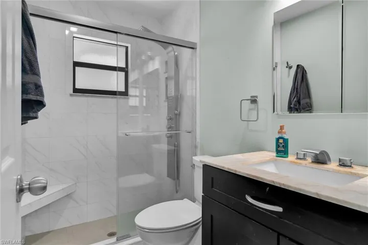 Full bathroom featuring vanity and a marble finish shower