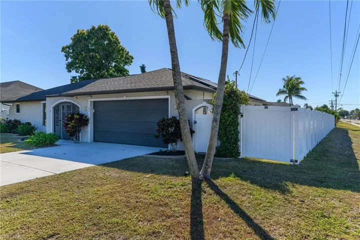 View of front of home with stucco siding, driveway, and a garage