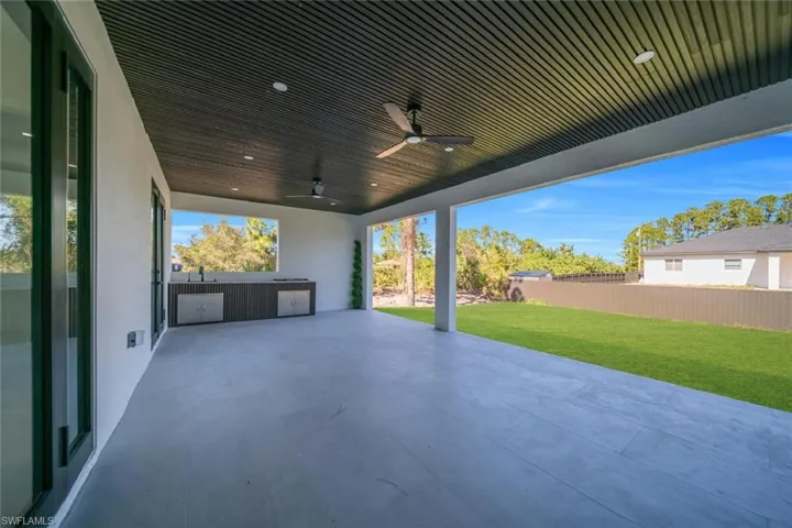 Fenced backyard with a ceiling fan and a patio