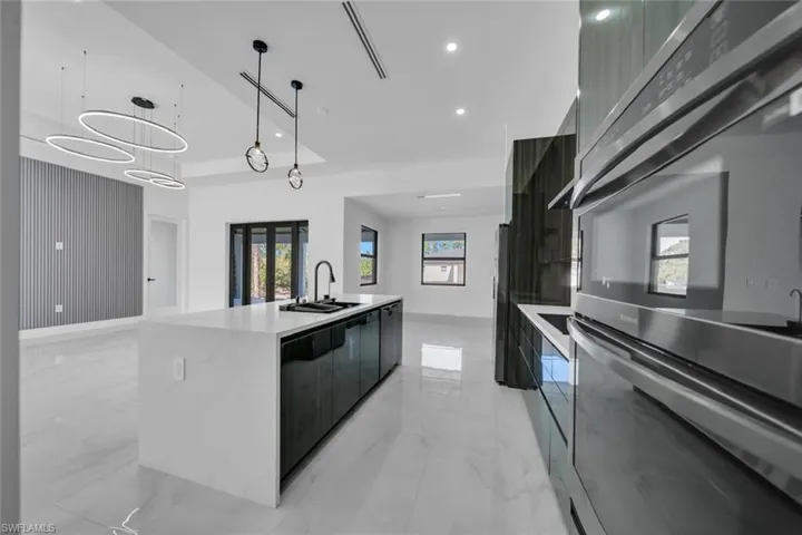 Kitchen featuring appliances with stainless steel finishes, modern cabinets, healthy amount of natural light, hanging light fixtures, and recessed lighting
